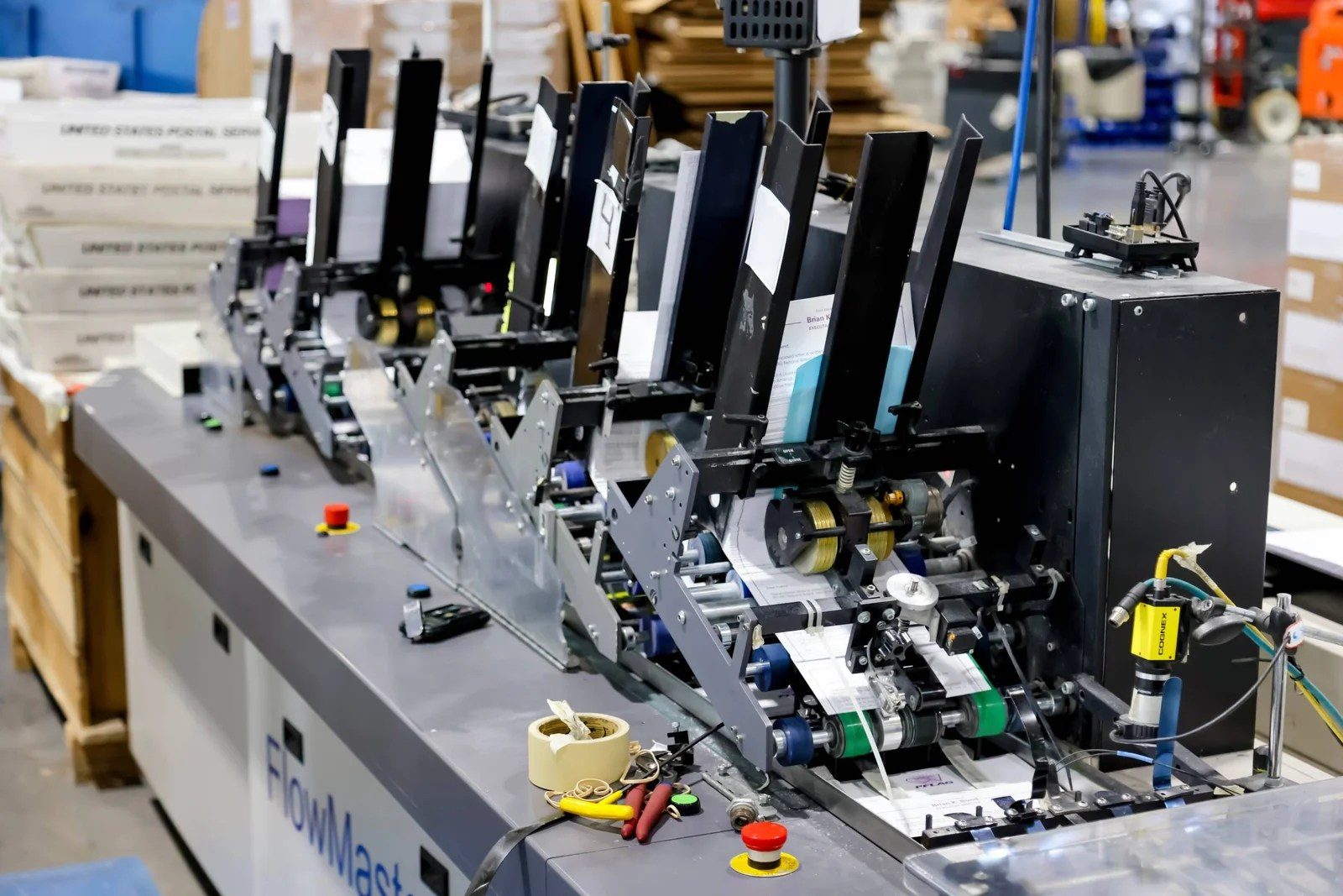 FlowMaster inserting line running letters with USPS trays staged beside it
